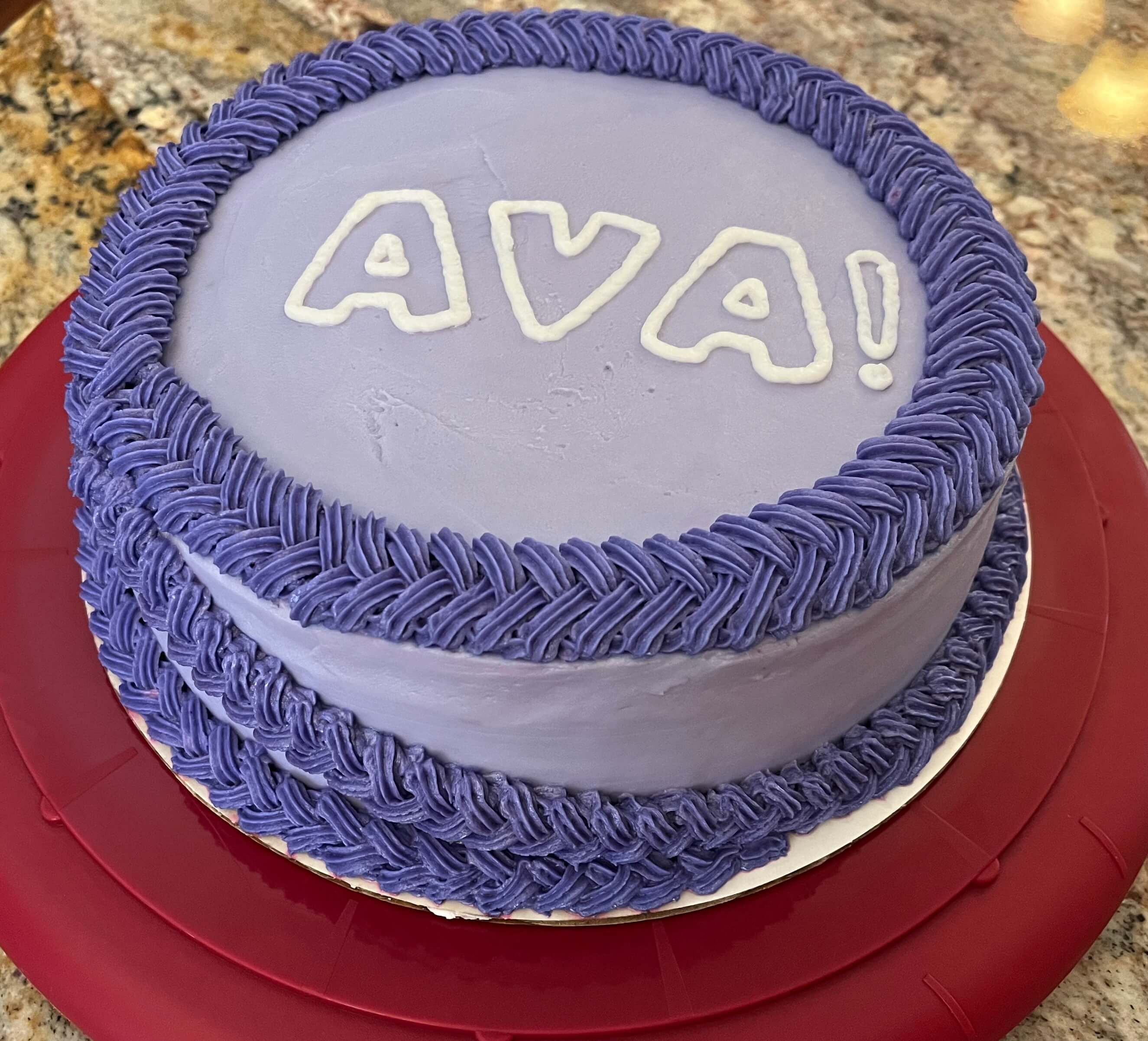 Decorated vanilla cake with purple frosting and a purple braid.