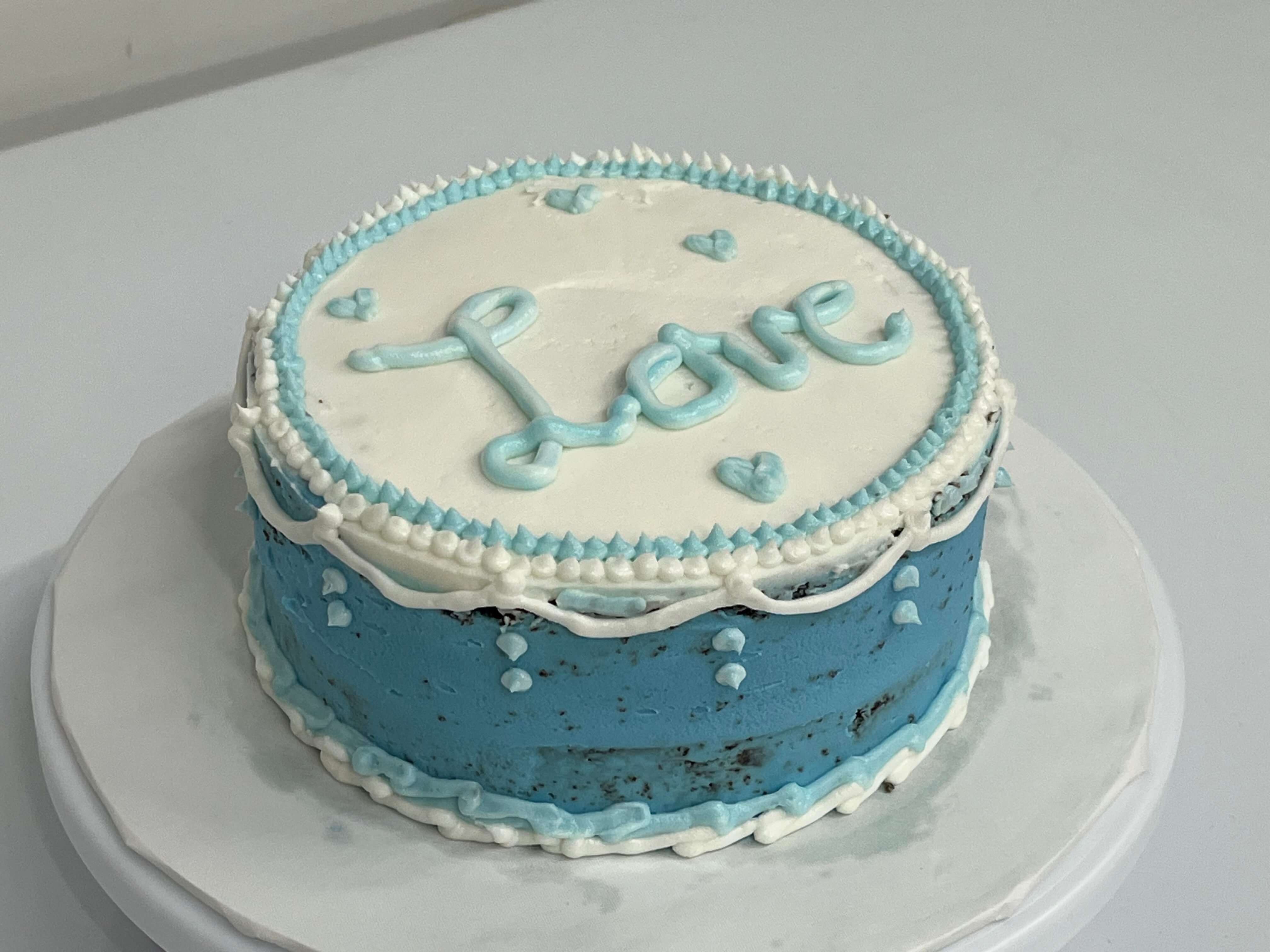 Two-layer 6-inch round chocolate cake decorated with semi-naked base and elegant accents.