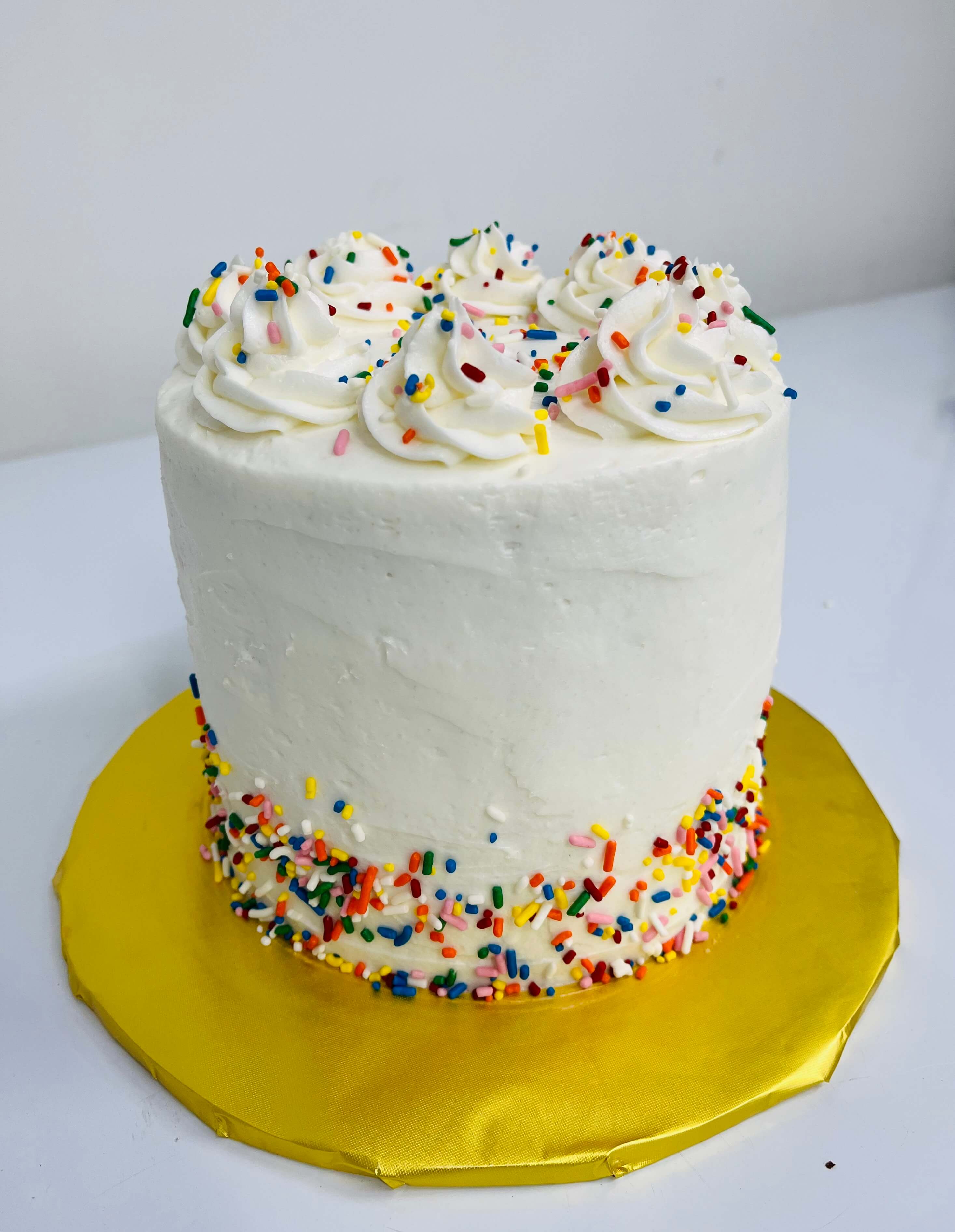Decorated simple sprinkle cakes with rainbow colored cake.