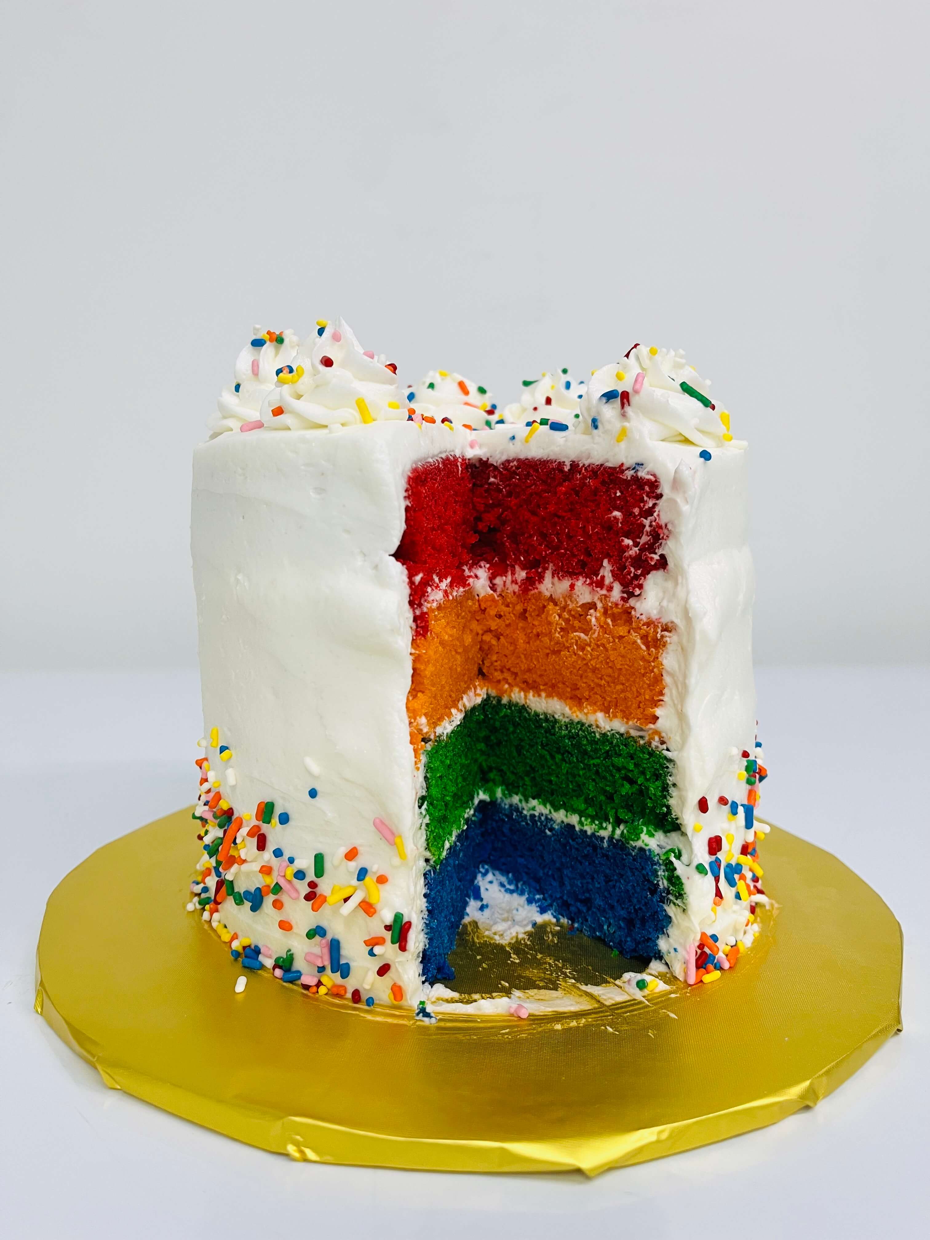 Decorated simple sprinkle cakes with rainbow colored cake.