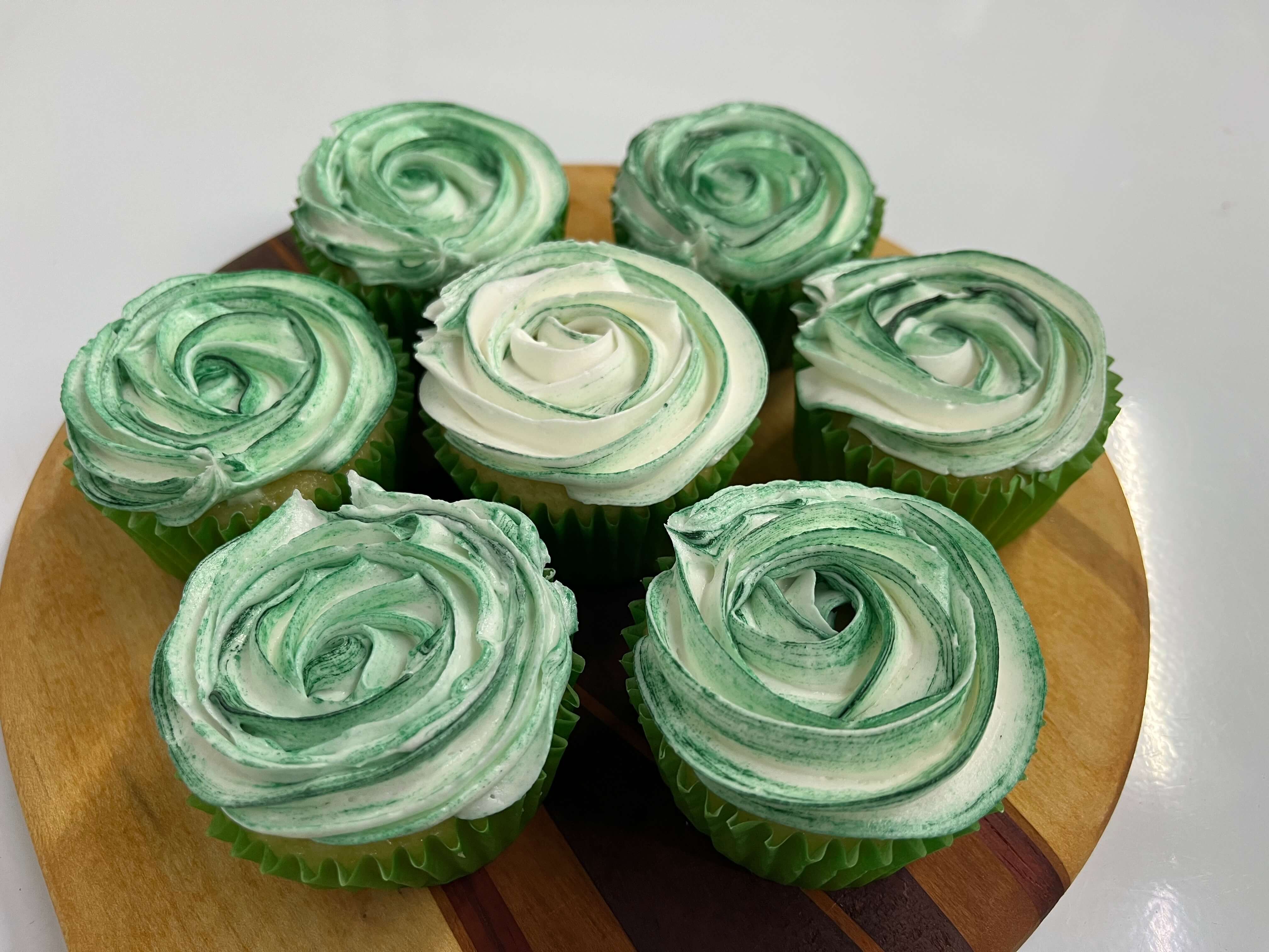 Decorated vanilla cupcakes with chocolate frosting swirled on top